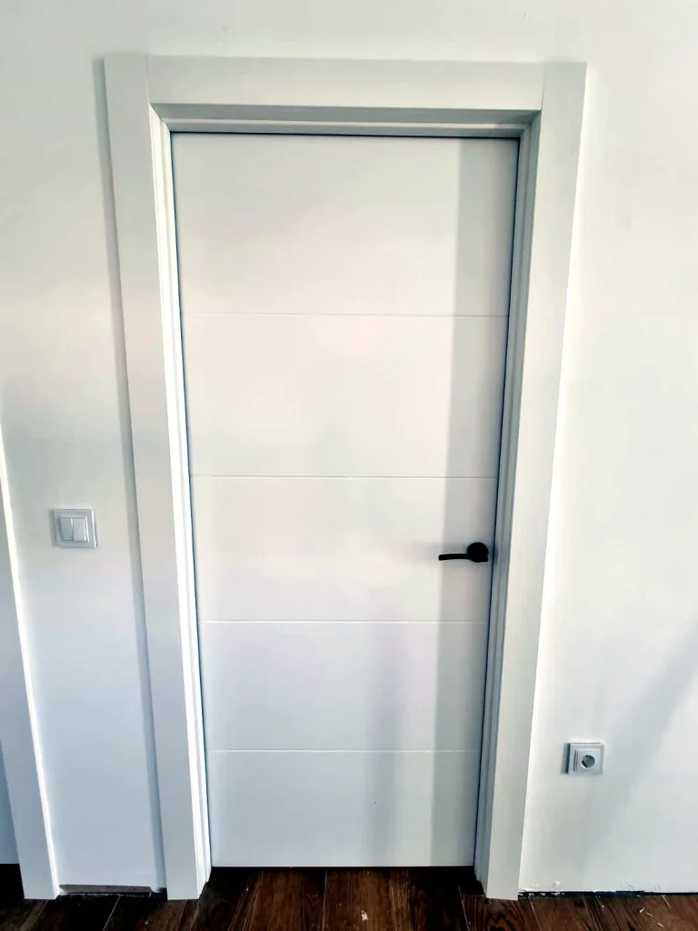 Puerta de interior lisa lacada en blanco con tirador negro, fabricada a medida en Murcia