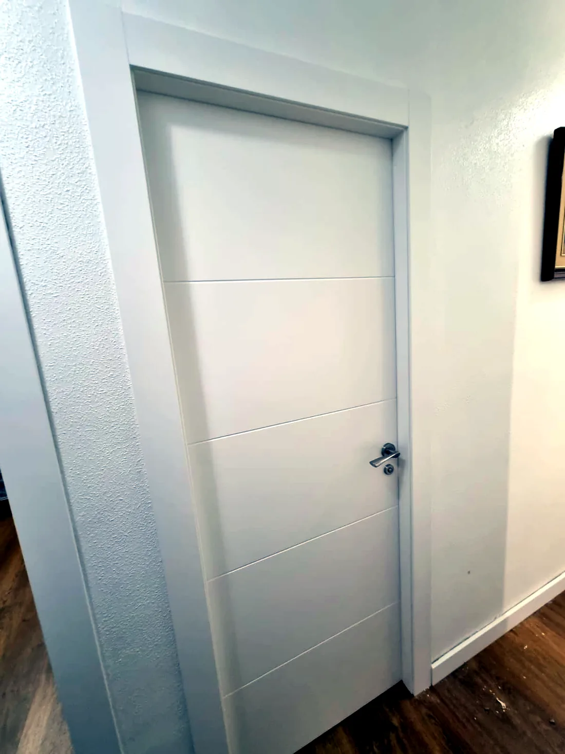 Pasillo de vivienda con puerta de interior lisa lacada en blanco a medida